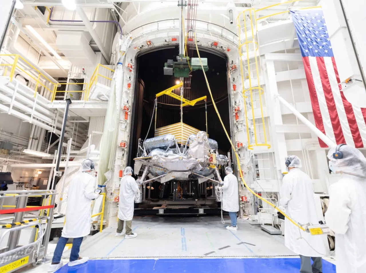 Technicians guide the Griffin-1 lunar lander into JPL’s tall test chamber.