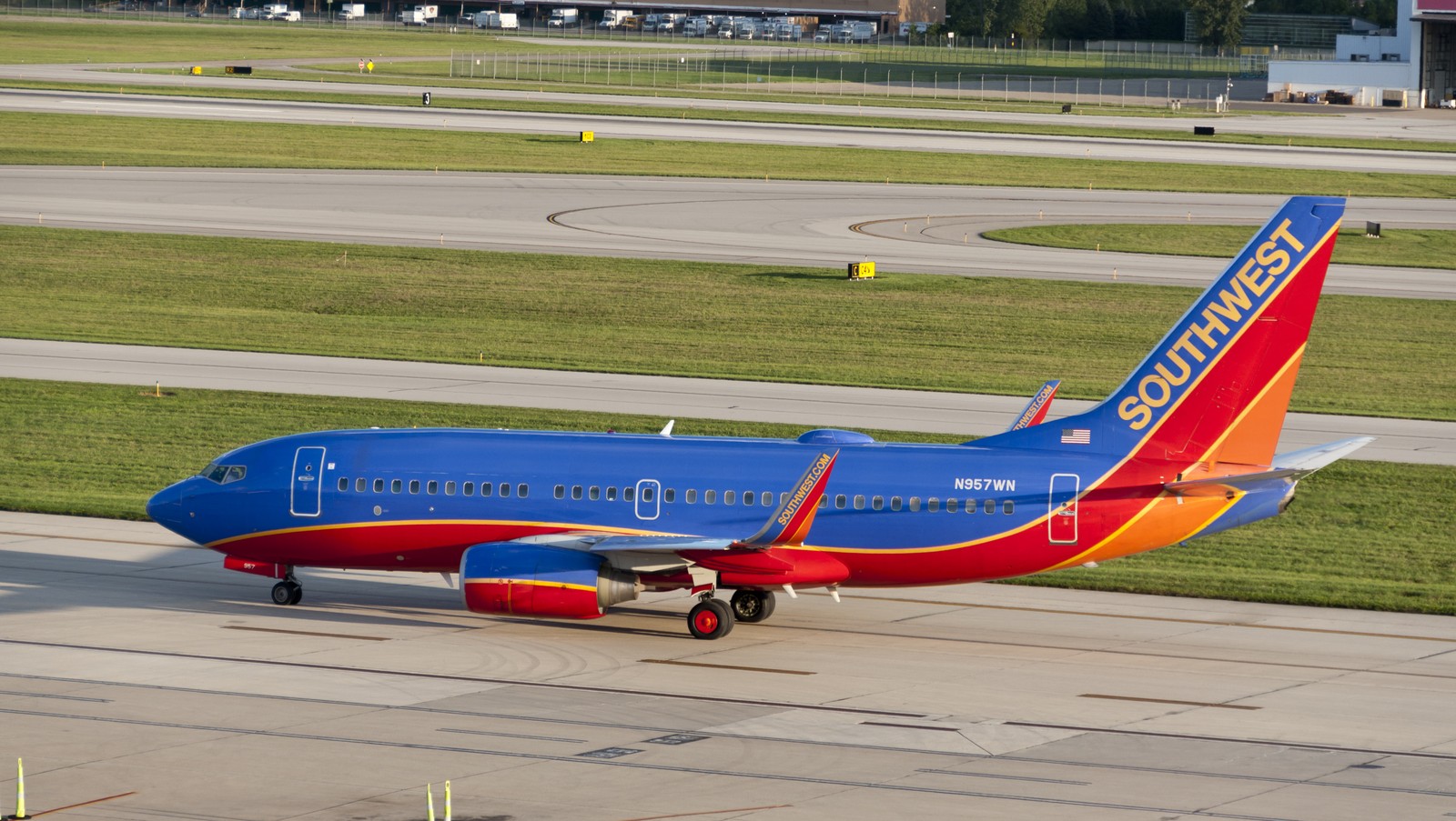 Blue, red and yellow Southwest jet viewed broadside on airport pavement, with its nose pointing left and tail surfaces visible.